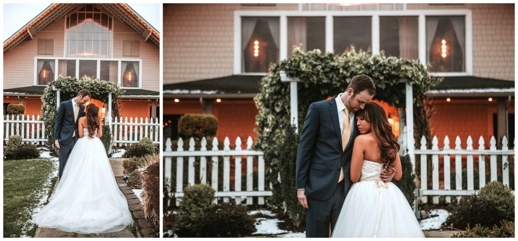 Premier snohomish & seattle wedding photographer | gsquared weddings photography a bride and groom stand close together in front of a vine covered gazebo and white picket fence on a snowy winter day capturing their snohomish wedding near seattle with a charming house in the background | serving snohomish seattle                   & beyond
