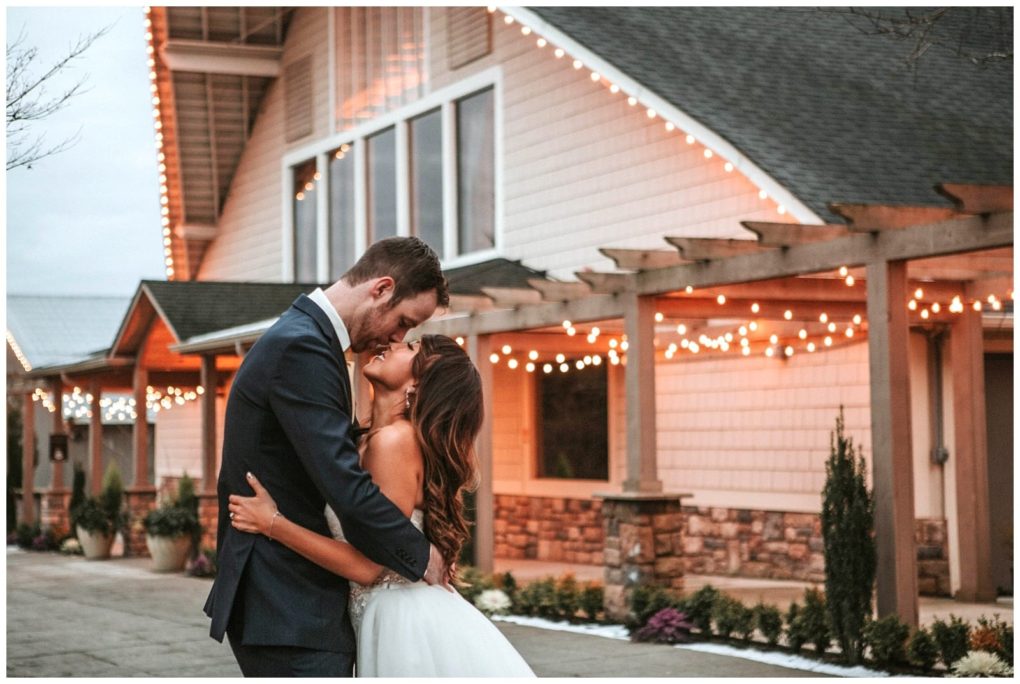 Premier snohomish & seattle wedding photographer | gsquared weddings photography a bride and groom embrace and smile at each other outside a snohomish building decorated with string lights creating a warm romantic atmosphere perfect for a seattle wedding engagement | serving snohomish seattle                   & beyond