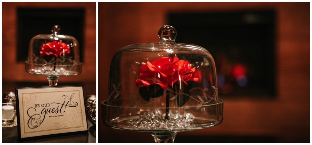 Premier snohomish & seattle wedding photographer | gsquared weddings photography a red rose under a glass dome sits on crystals next to a framed be our guest sign with a drawing of lumière from beauty and the beast adding fairytale charm to this snohomish seattle wedding or engagement setting | serving snohomish seattle                   & beyond