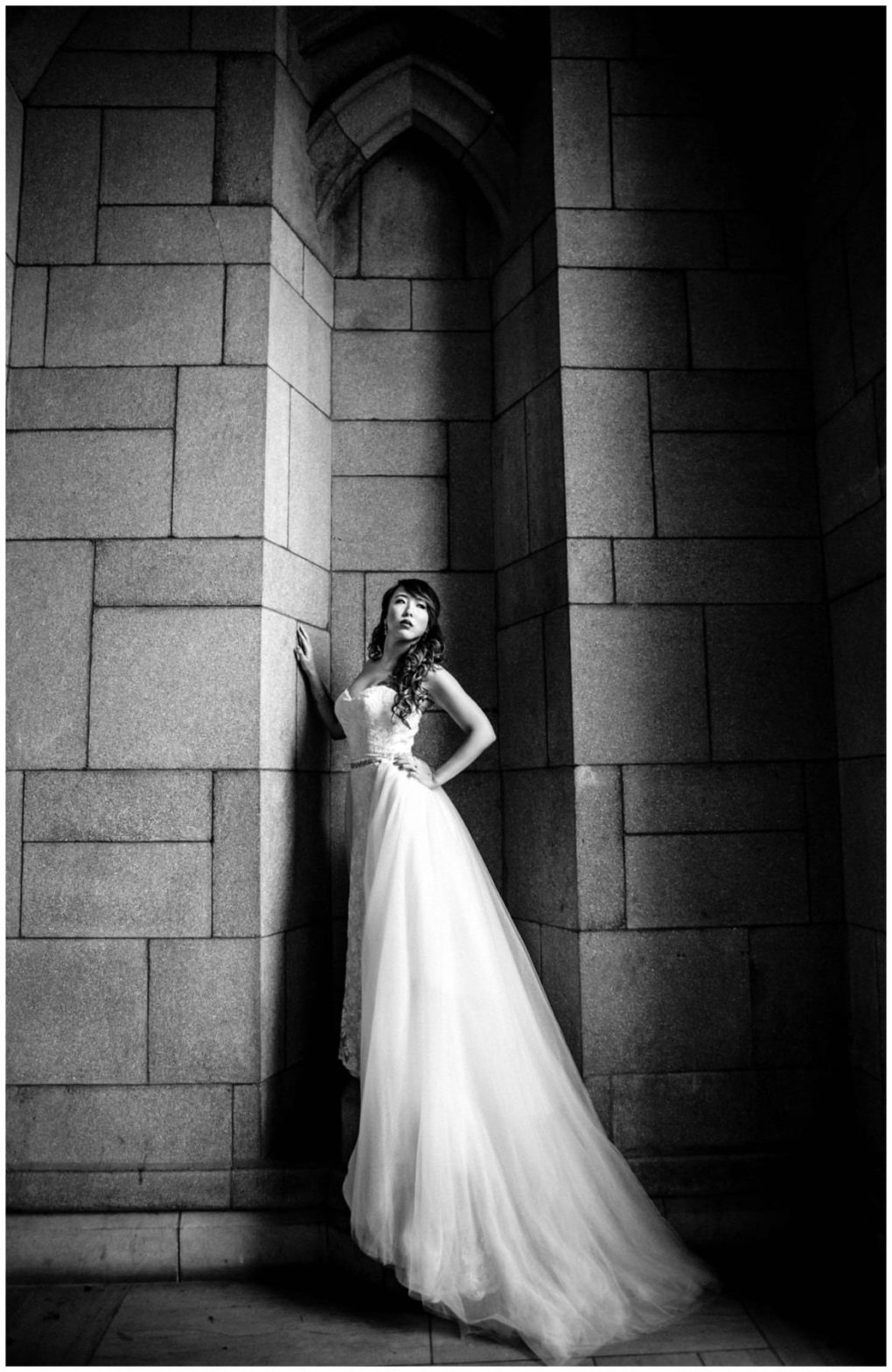 Premier snohomish & seattle wedding photographer | gsquared weddings photography a woman in a flowing wedding gown stands against a tall stone wall with dramatic shadows looking upward Captured in black and white this snohomish wedding scene exudes timeless elegant charm | serving snohomish seattle                   & beyond