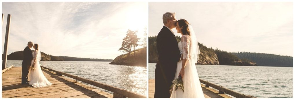 Premier snohomish & seattle wedding photographer | gsquared weddings photography a bride and groom stand on a wooden dock by the water embracing and smiling at each other during their snohomish wedding with scenic hills and a partly cloudy sky in the background | serving snohomish seattle                   & beyond
