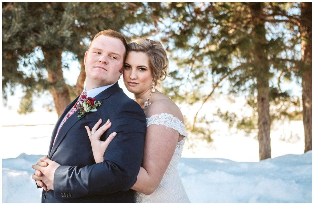 Premier snohomish & seattle wedding photographer | gsquared weddings photography a bride in a white off the shoulder gown embraces her groom in a dark suit and floral tie they pose together outdoors amid snowy evergreens capturing a romantic snohomish wedding moment near seattle | serving snohomish seattle                   & beyond