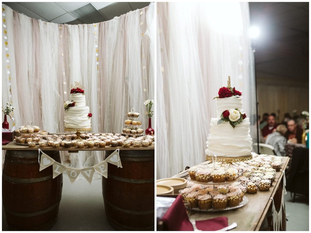 Premier snohomish & seattle wedding photographer | gsquared weddings photography a wedding dessert table at a snohomish celebration features a white tiered cake with red and white flowers cupcakes and a love banner Set on barrels draped with curtains this seattle area wedding scene includes guests in the background | serving snohomish seattle                   & beyond
