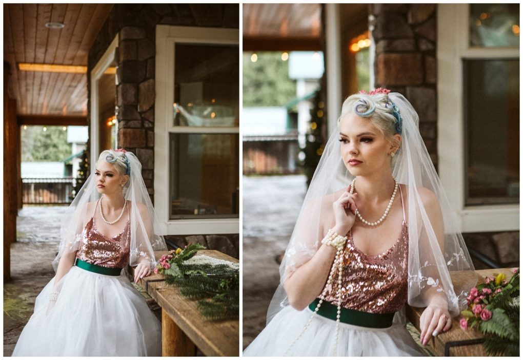 Premier snohomish & seattle wedding photographer | gsquared weddings photography a bride with pastel blue hair wearing a sparkling pink sequin top white tulle skirt and pearl necklace poses outdoors against a rustic wooden and stone building in snohomish She gazes thoughtfully holding her veil and bouquet | serving snohomish seattle                   & beyond