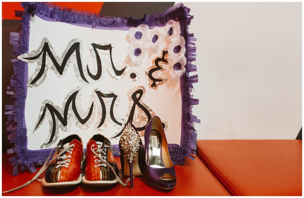Premier snohomish & seattle wedding photographer | gsquared weddings photography a sign reading mr & mrs  perfect for a snohomish or seattle wedding is decorated with purple fringe and flowers standing behind a pair of red sneakers and two high heeled shoes on a vibrant red surface | serving snohomish seattle                   & beyond