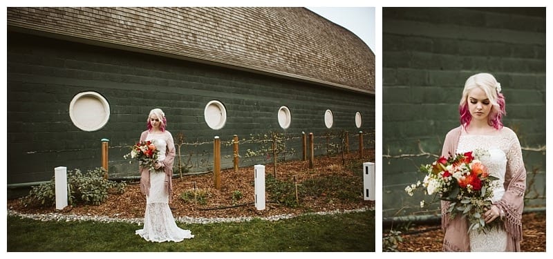 Premier snohomish & seattle wedding photographer | gsquared weddings photography a bride with pink hair in a white lace dress holds a colorful bouquet while standing outside a green building with round windows at her snohomish wedding A close up shows her looking down surrounded by greenery and flowers | serving snohomish seattle                   & beyond