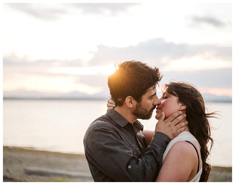 Premier snohomish & seattle wedding photographer | gsquared weddings photography a couple shares a romantic kiss at sunset by a lake near seattle with soft sunlight illuminating their faces and the serene water in the backgrounda perfect moment for a snohomish wedding engagement | serving snohomish seattle                   & beyond