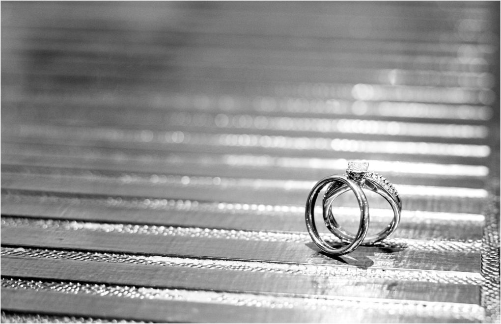 Premier snohomish & seattle wedding photographer | gsquared weddings photography two wedding rings one with a prominent diamond rest upright on a reflective textured surface The blurred background highlights the shine and detailperfect for a snohomish seattle wedding or engagement moment | serving snohomish seattle                   & beyond