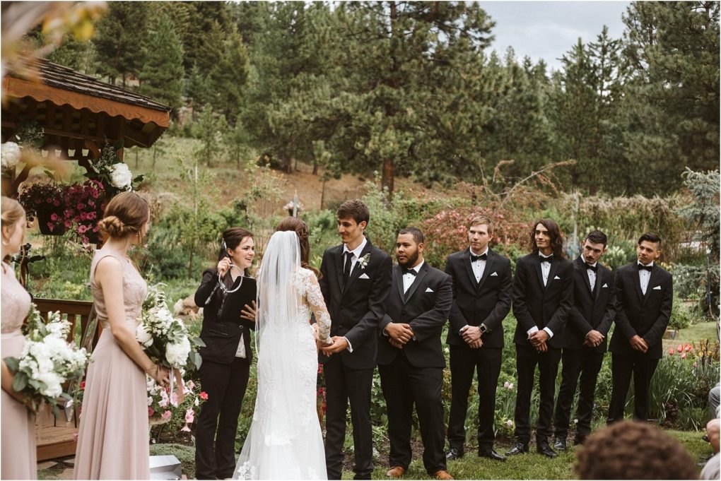 Premier snohomish & seattle wedding photographer | gsquared weddings photography a bride and groom stand at their snohomish outdoor wedding ceremony with bridesmaids and groomsmen As the officiant speaks guests watch amid lush greenery The wedding party wears black suits and blush dresses for this seattle celebration | serving snohomish seattle                   & beyond