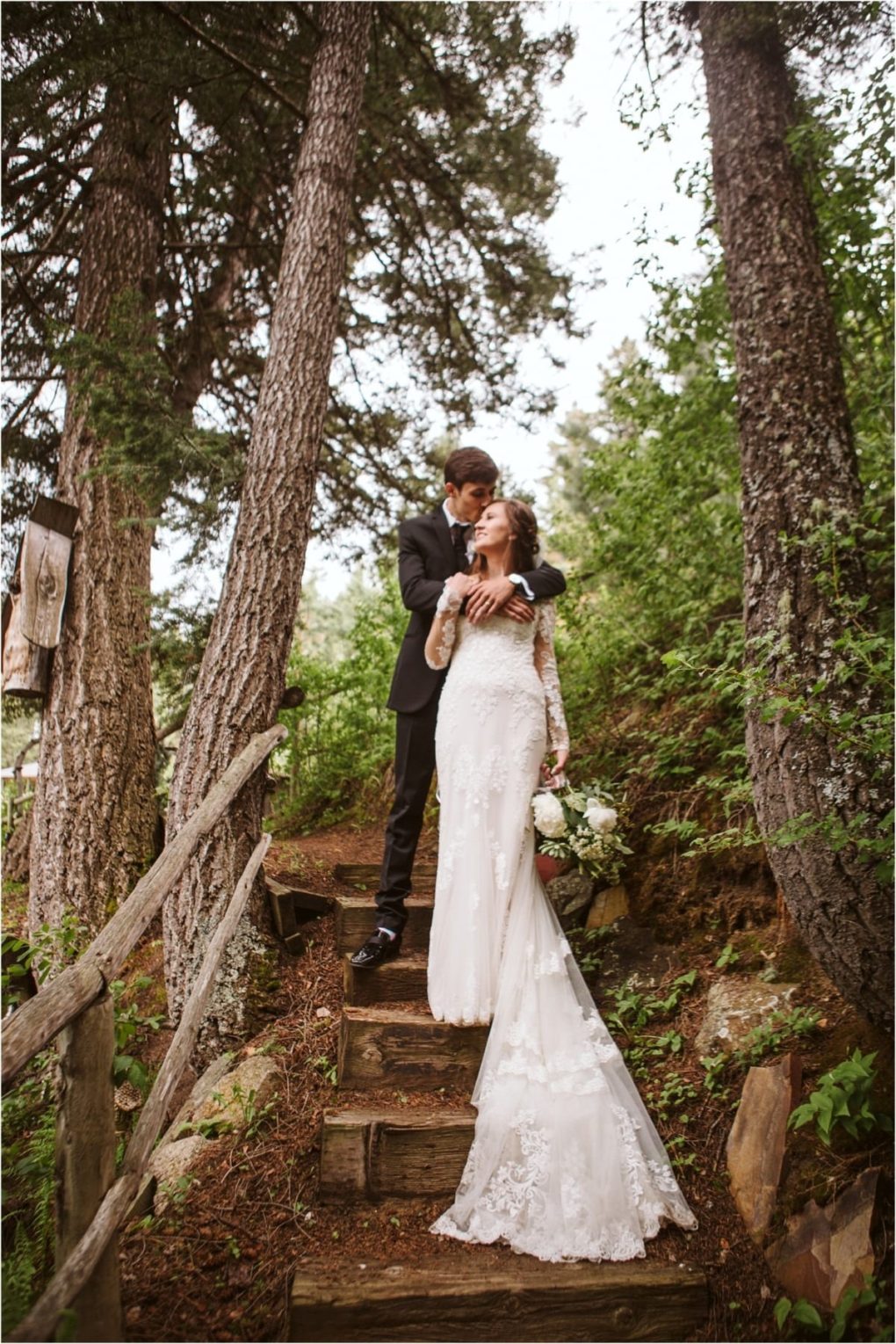 Premier snohomish & seattle wedding photographer | gsquared weddings photography a bride in a white lace gown holding a bouquet and a groom in a suit stand on rustic outdoor steps embracing lovingly among tall treesa romantic snohomish seattle wedding engagement in the heart of the forest | serving snohomish seattle                   & beyond