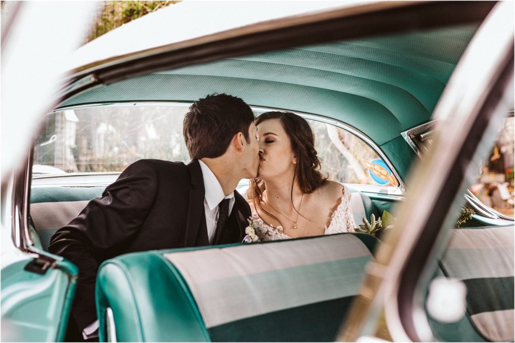 Premier snohomish & seattle wedding photographer | gsquared weddings photography a bride and groom share a kiss while sitting in the backseat of a vintage car with teal and white upholstery captured through the open car door at their charming snohomish seattle wedding | serving snohomish seattle                   & beyond