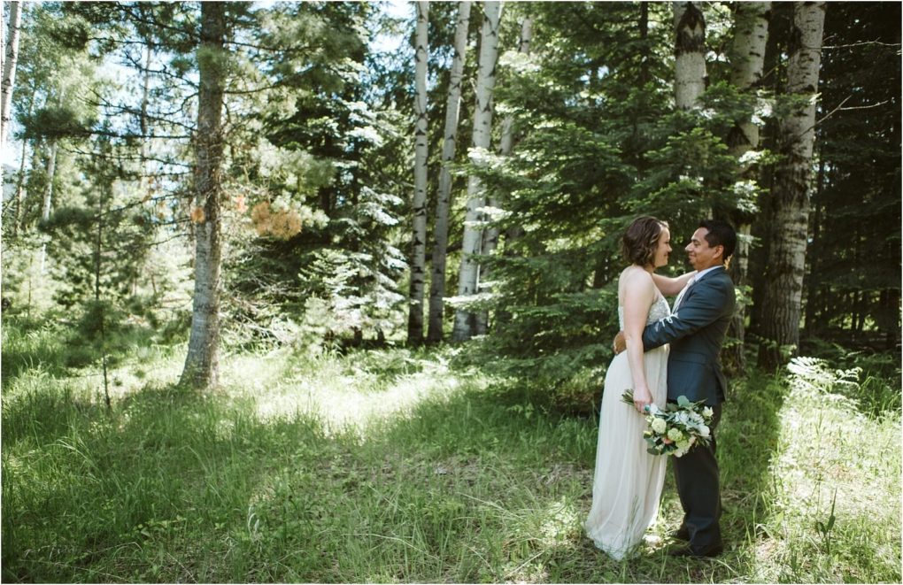 Premier snohomish & seattle wedding photographer | gsquared weddings photography a bride and groom stand facing each other in a sunlit forest near snohomish surrounded by tall green trees The bride holds a bouquet and smiles at the groom both dressed beautifully and radiating happiness and love on their wedding day | serving snohomish seattle                   & beyond