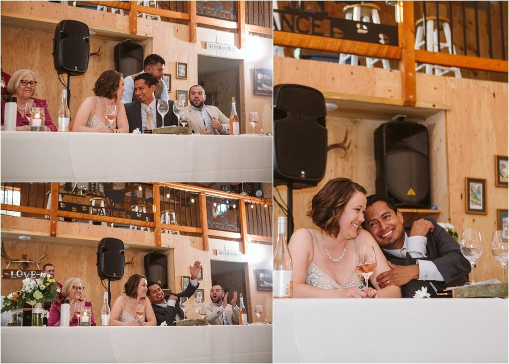 Premier snohomish & seattle wedding photographer | gsquared weddings photography a snohomish seattle wedding reception scene with a newlywed couple sitting at a long table laughing and embracing surrounded by guests raising glasses and enjoying the joyful celebration in a rustic venue | serving snohomish seattle                   & beyond