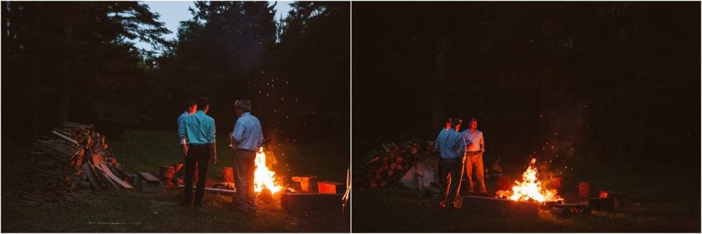 Premier snohomish & seattle wedding photographer | gsquared weddings photography two people stand near a campfire at dusk surrounded by trees and stacked firewood The fire casts a warm glow as they talk outdoors capturing a cozy snohomish engagement moment perfect for seattle area wedding inspiration | serving snohomish seattle                   & beyond