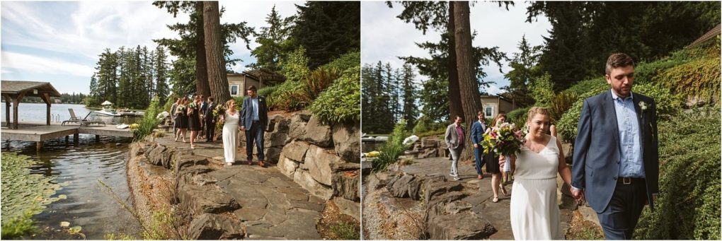 Premier snohomish & seattle wedding photographer | gsquared weddings photography a bride and groom walk hand in hand along a rocky lakeside path near snohomish followed by their wedding party Tall trees a wooden dock and lake water are visible in the background on a sunny day | serving snohomish seattle                   & beyond