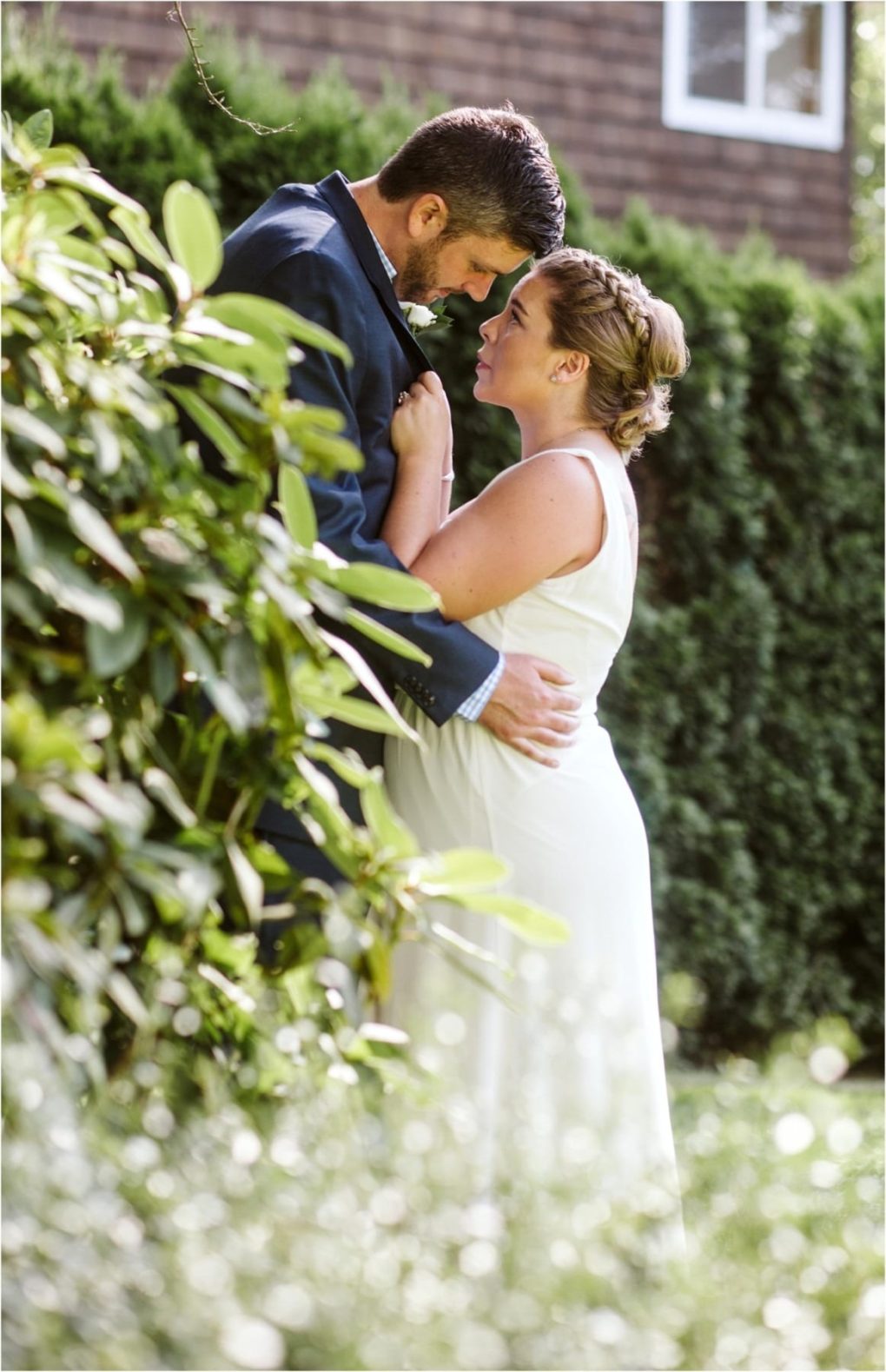 Premier snohomish & seattle wedding photographer | gsquared weddings photography a couple embraces closely outside gazing into each others eyes during their snohomish wedding engagement The woman wears a white dress the man a dark suit surrounded by lush green bushes and natural seattle sunlight | serving snohomish seattle                   & beyond