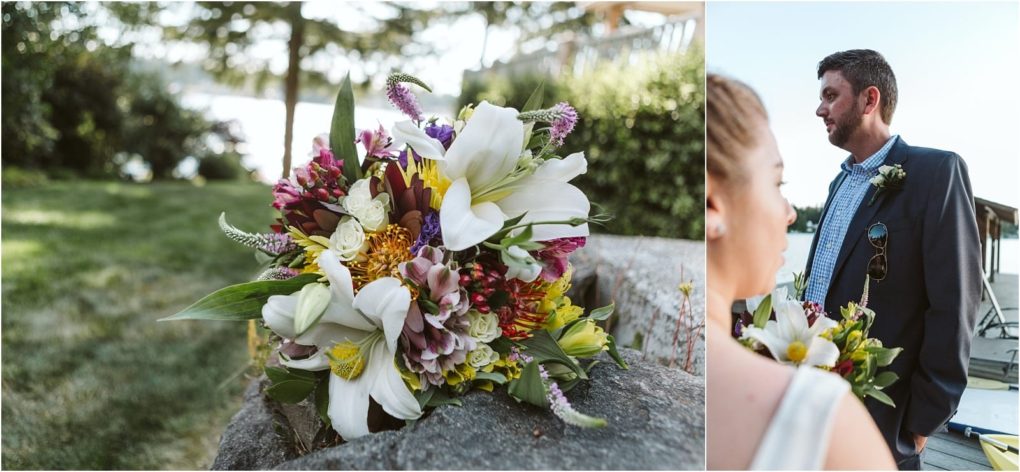 Premier snohomish & seattle wedding photographer | gsquared weddings photography a colorful bridal bouquet with lilies roses and greenery rests on a stone ledge outdoors during a snohomish seattle wedding nearby a man in a suit talks to a woman with a lake and trees in the background | serving snohomish seattle                   & beyond