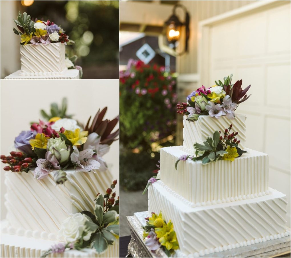 Premier snohomish & seattle wedding photographer | gsquared weddings photography a two tiered white cake with diagonal textured frosting topped and decorated with colorful fresh flowers displayed outdoors near a garage and blooming plantsperfect for a snohomish or seattle wedding engagement | serving snohomish seattle                   & beyond