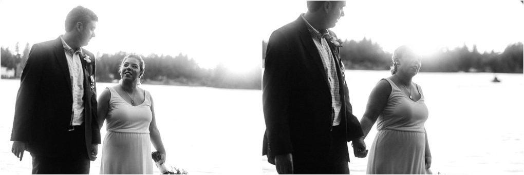 Premier snohomish & seattle wedding photographer | gsquared weddings photography a black and white photo shows a couple dressed formally holding hands and smiling at each other by a lake in snohomish with trees and sunlight in the backgrounda beautiful moment from their seattle wedding engagement | serving snohomish seattle                   & beyond