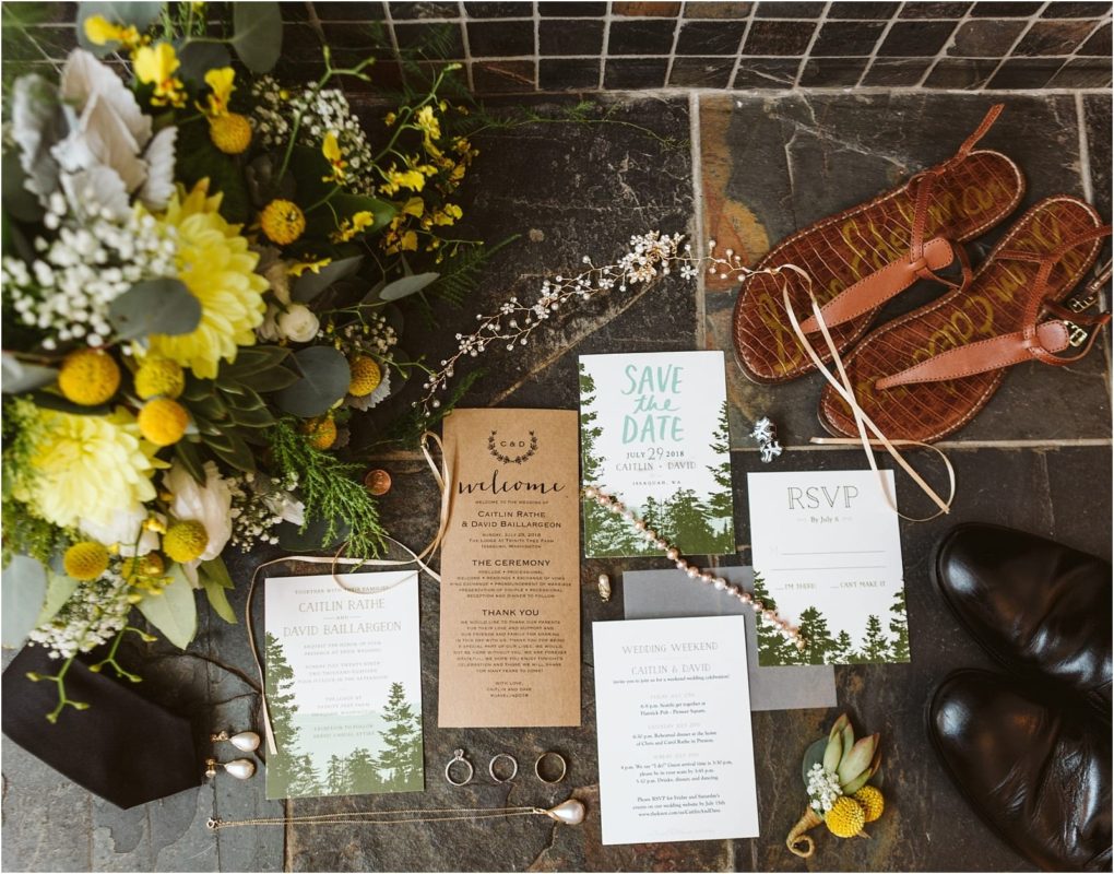 Premier snohomish & seattle wedding photographer | gsquared weddings photography flat lay of wedding invitations and rsvps with a forest theme surrounded by yellow and white flowers rings earrings a tie brown sandals black shoes and small greeneryperfect inspiration for your snohomish seattle wedding or engagement | serving snohomish seattle                   & beyond