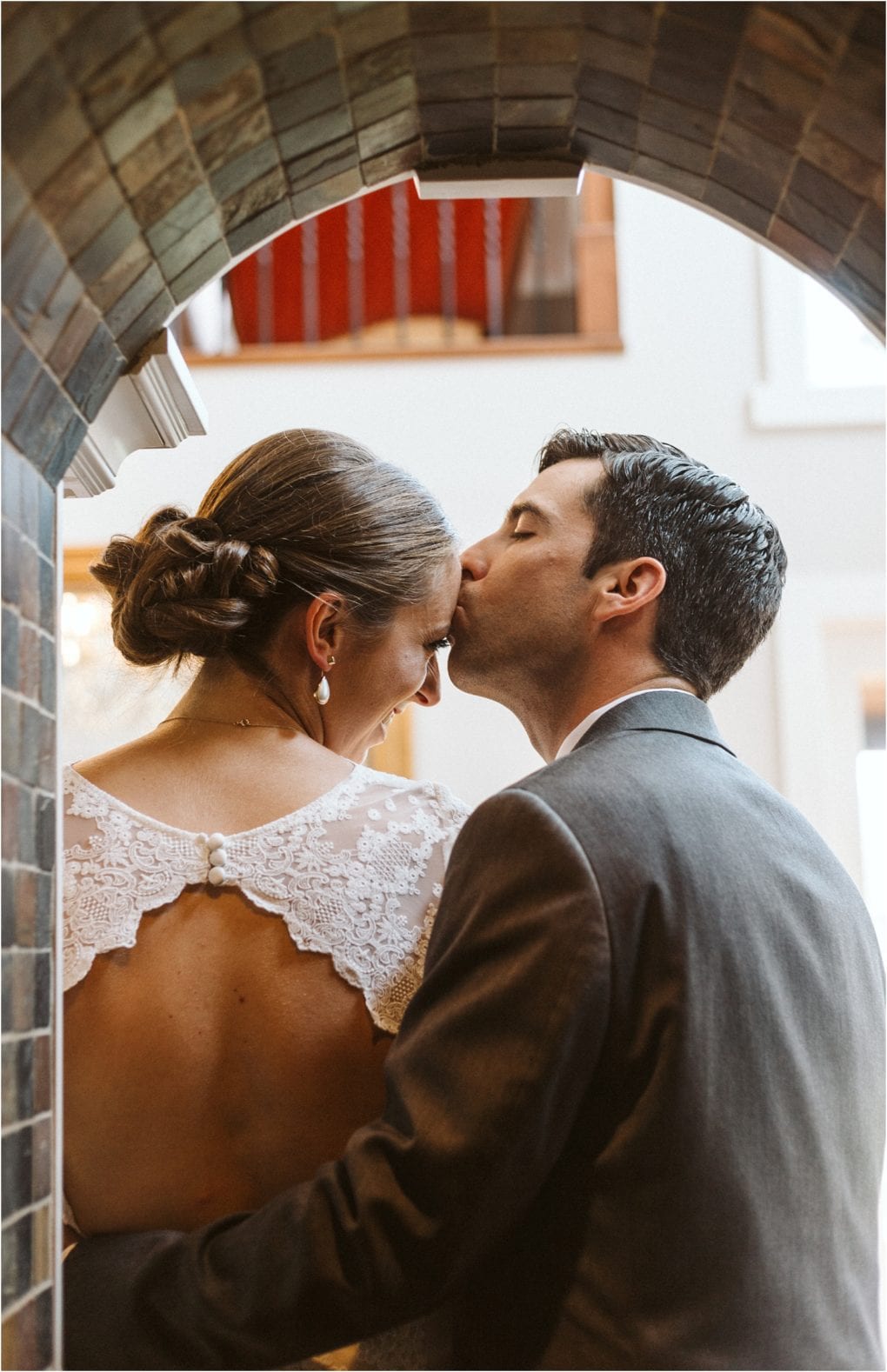 Premier snohomish & seattle wedding photographer | gsquared weddings photography a groom in a suit kisses his bride on the forehead under a tiled archway at their snohomish wedding The bride in a lace dress with an open back and elegant bun shares an intimate moment of happiness | serving snohomish seattle                   & beyond