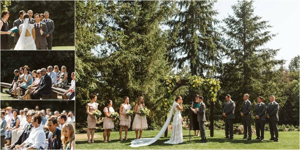 Premier snohomish & seattle wedding photographer | gsquared weddings photography a bride and groom stand under a floral arch with their wedding party in an outdoor snohomish ceremony guests sit on benches surrounded by tall pine trees and bright seattle sunlight | serving snohomish seattle                   & beyond