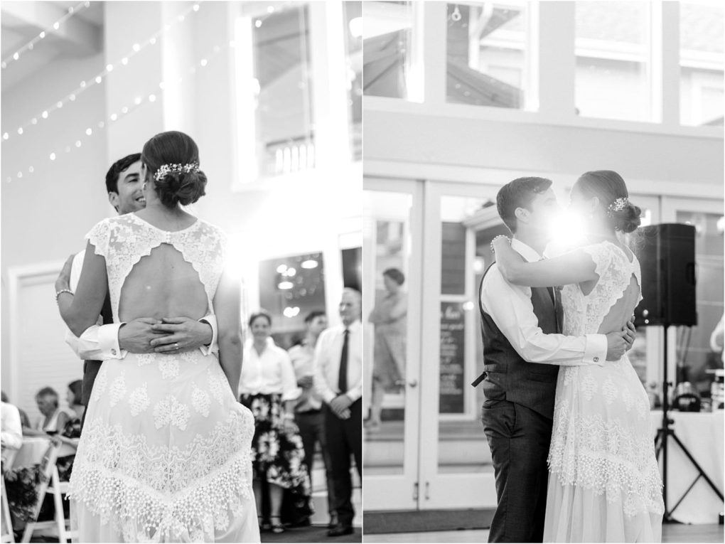 Premier snohomish & seattle wedding photographer | gsquared weddings photography black and white photo of a bride and groom sharing their first dance at a snohomish seattle wedding The bride wears a lacy backless gown as they embrace guests watching while sunlight shines between them creating a soft glow | serving snohomish seattle                   & beyond
