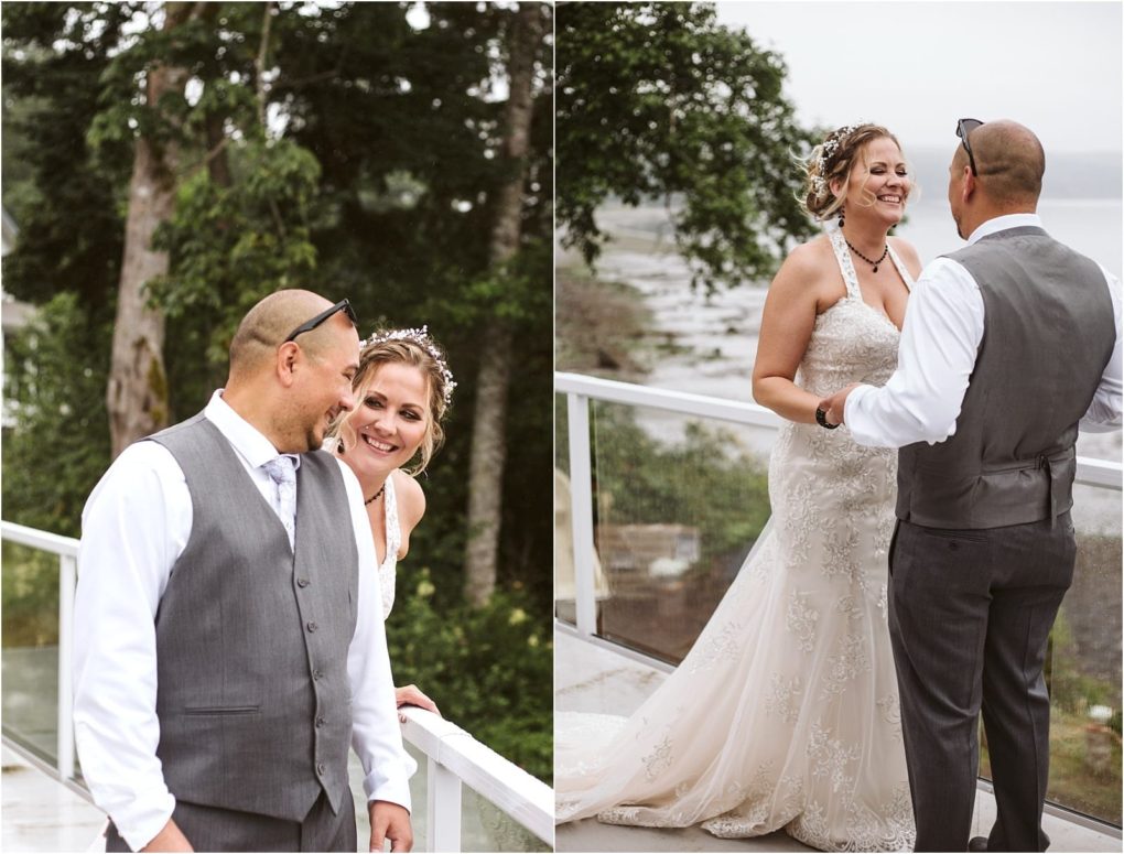 Premier snohomish & seattle wedding photographer | gsquared weddings photography a bride in a lace wedding dress and a groom in a gray vest and tie smile and laugh together on an outdoor balcony at their snohomish seattle wedding overlooking trees and water | serving snohomish seattle                   & beyond