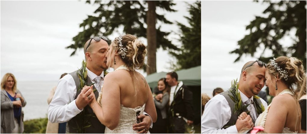 Premier snohomish & seattle wedding photographer | gsquared weddings photography a bride and groom share a kiss and embrace outdoors at their snohomish wedding surrounded by guests and tall trees with the ocean visible in the background on a cloudy seattle day | serving snohomish seattle                   & beyond