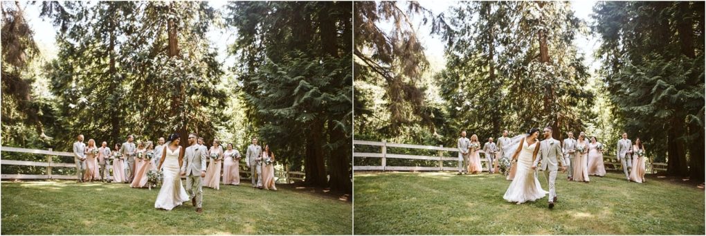 Premier snohomish & seattle wedding photographer | gsquared weddings photography a wedding party dressed in light colored attire walks together on a grassy lawn surrounded by tall green trees and a white wooden fence under bright sunlight at a picturesque snohomish seattle wedding | serving snohomish seattle                   & beyond