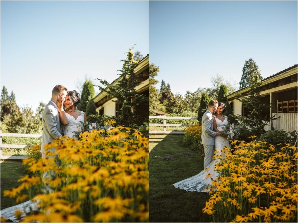 Premier snohomish & seattle wedding photographer | gsquared weddings photography a bride and groom stand close together in a garden beside a rustic building surrounded by vibrant yellow flowers under a clear blue skya perfect moment for a snohomish seattle wedding engagement | serving snohomish seattle                   & beyond
