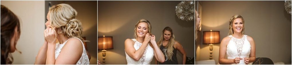 Premier snohomish & seattle wedding photographer | gsquared weddings photography a blonde bride in a white lace dress smiles and puts on earrings while getting ready for her snohomish wedding accompanied by a bridesmaid in a warmly lit room with beige walls and a decorative lamp | serving snohomish seattle                   & beyond
