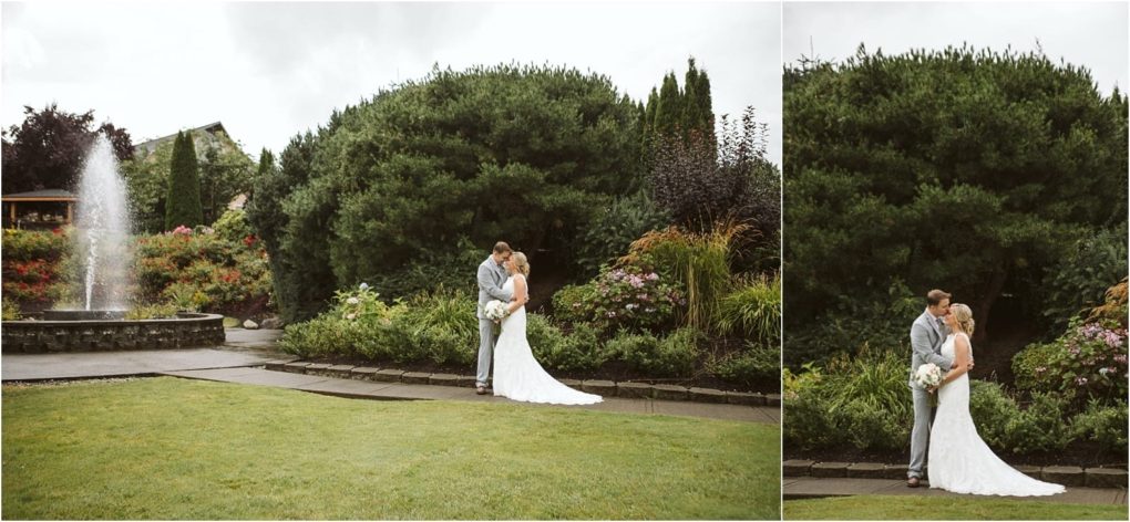 Premier snohomish & seattle wedding photographer | gsquared weddings photography a snohomish bride and groom share a kiss in a lush garden beside blooming flowers and greenery with a stone fountain spraying water in the background on a cloudy seattle wedding day | serving snohomish seattle                   & beyond