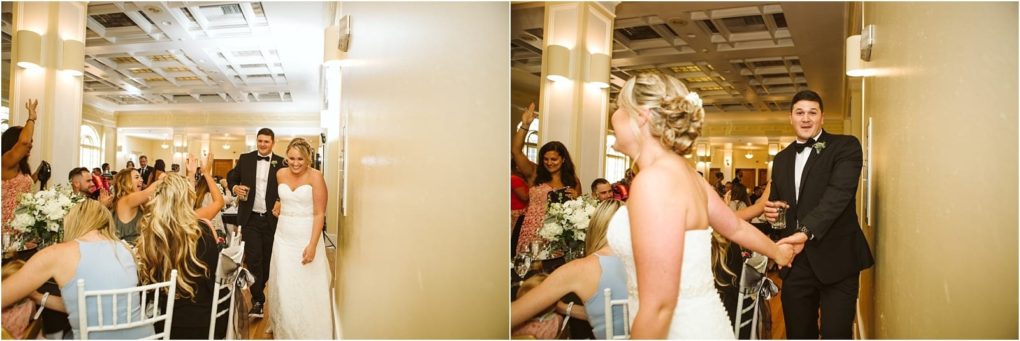 Premier snohomish & seattle wedding photographer | gsquared weddings photography a bride in a white gown and a groom in a black tuxedo enter a bright elegant snohomish reception room smiling and holding hands as seated guests cheer and celebrate their seattle wedding arrival | serving snohomish seattle                   & beyond