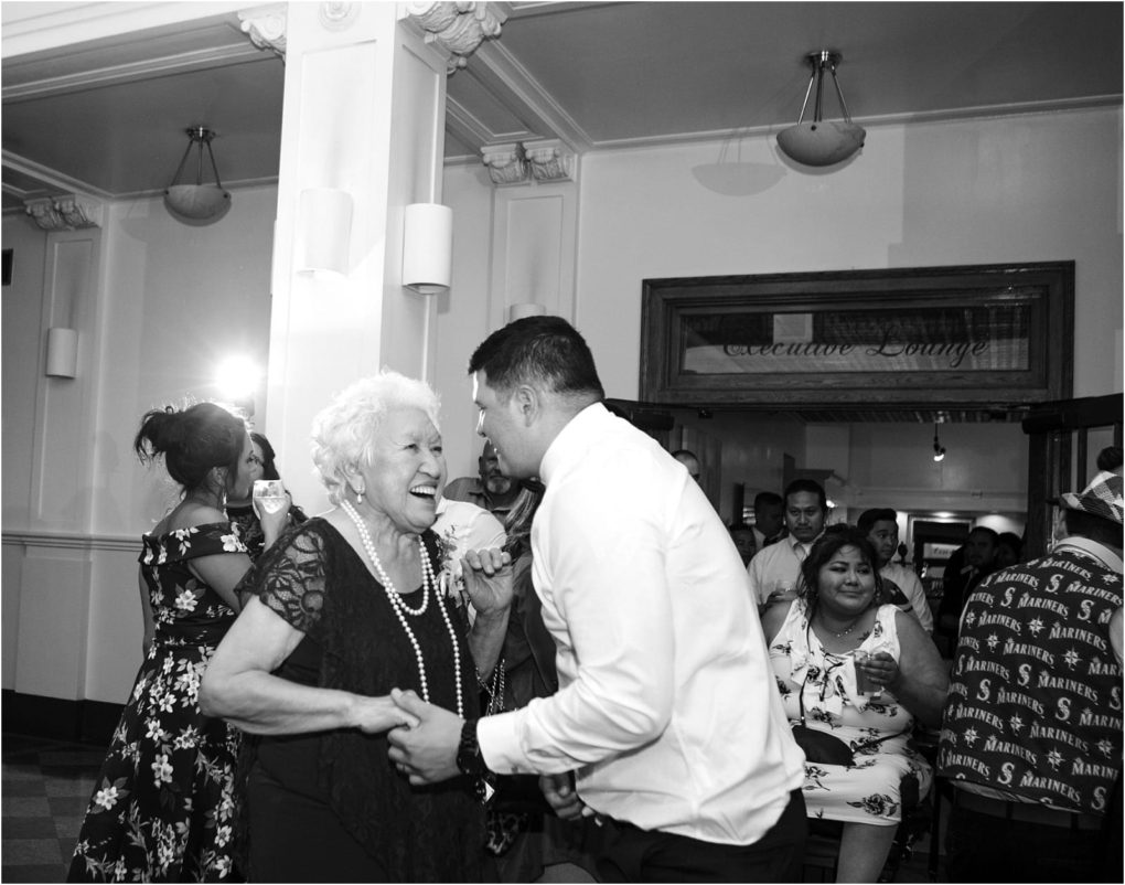 Premier snohomish & seattle wedding photographer | gsquared weddings photography a joyful elderly woman and a young man dance together at a lively indoor gathering in snohomish Surrounded by smiling guests the festive atmosphere feels like a seattle wedding or engagement celebration | serving snohomish seattle                   & beyond