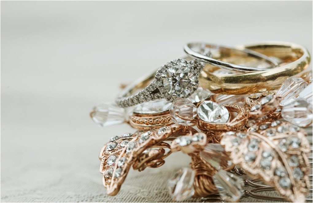 Premier snohomish & seattle wedding photographer | gsquared weddings photography close up of a diamond engagement ring a gold wedding band and a silver band resting on a decorative crystal embellished accessory with rose gold leaves and clear beadsperfect for a snohomish seattle wedding engagement | serving snohomish seattle                   & beyond