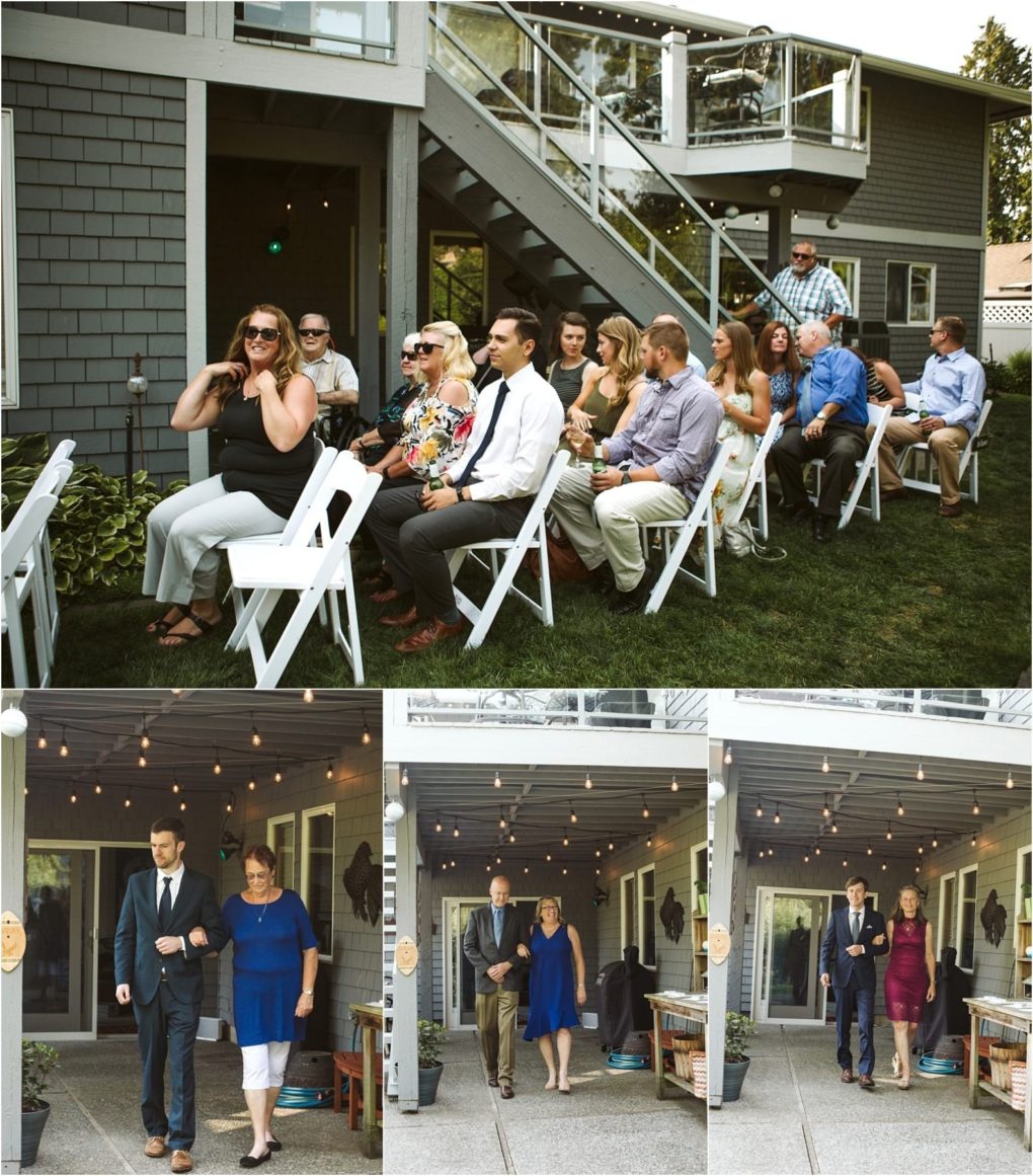 Premier snohomish & seattle wedding photographer | gsquared weddings photography a group of people sit on white folding chairs outdoors facing forward as others in formal attire walk down a pathcapturing the start of a snohomish seattle wedding ceremony at a house with a balcony and string lights | serving snohomish seattle                   & beyond