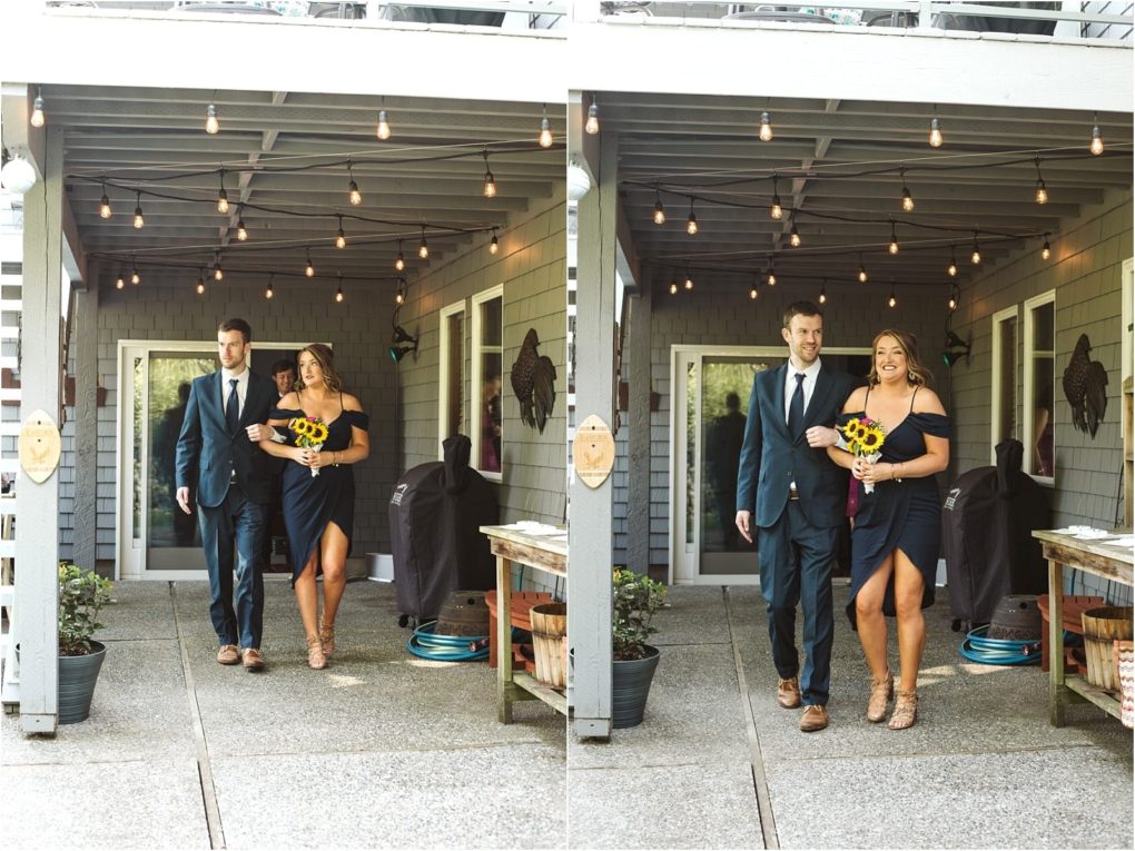 Premier snohomish & seattle wedding photographer | gsquared weddings photography a man in a suit escorts a woman in a dark blue off shoulder dress both smiling as they walk under string lights on a covered patio at their snohomish engagement The woman holds a yellow sunflower bouquet | serving snohomish seattle                   & beyond