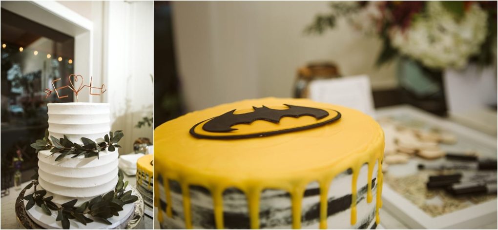 Premier snohomish & seattle wedding photographer | gsquared weddings photography two cakes on display one white frosted cake with green leaves and a heart shaped wire topper perfect for a snohomish seattle wedding or engagement and another cake with yellow icing dripping down and a bold black batman logo on top | serving snohomish seattle                   & beyond