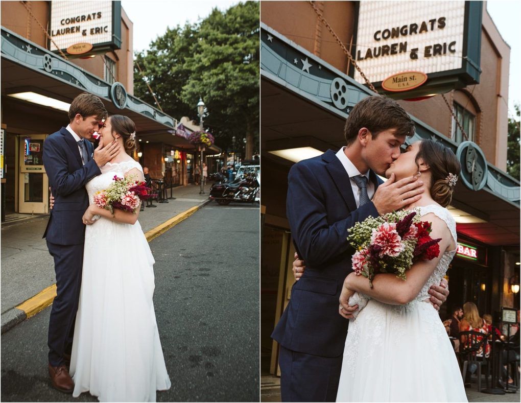 Premier snohomish & seattle wedding photographer | gsquared weddings photography a bride and groom kiss outside a theater marquee reading congrats lauren & eric after their snohomish wedding The groom wears a navy suit while the bride holds red and white flowers and stuns in a classic white gown | serving snohomish seattle                   & beyond