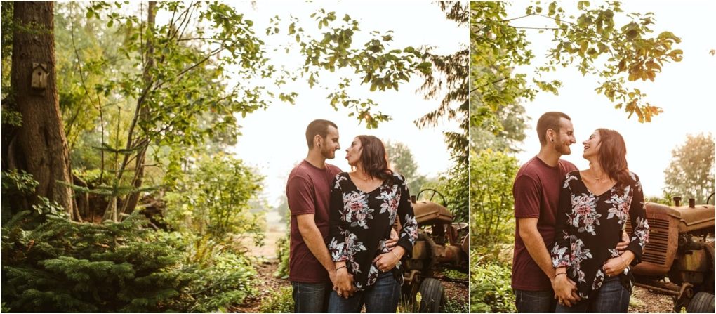 Premier snohomish & seattle wedding photographer | gsquared weddings photography a couple stands outdoors holding hands smiling at each other during their snohomish seattle wedding engagement They are surrounded by greenery and old farm equipment with sunlight streaming through the trees | serving snohomish seattle                   & beyond