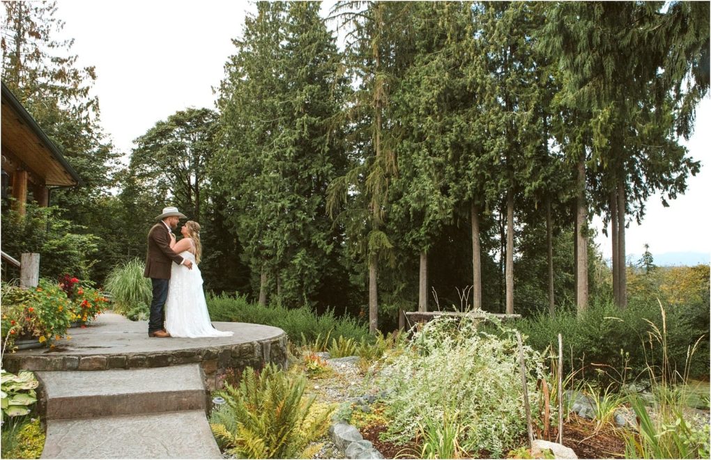 Premier snohomish & seattle wedding photographer | gsquared weddings photography a bride and groom share an intimate moment on a stone patio surrounded by greenery and tall trees capturing the charm of a snohomish seattle wedding in a lush outdoor setting | serving snohomish seattle                   & beyond