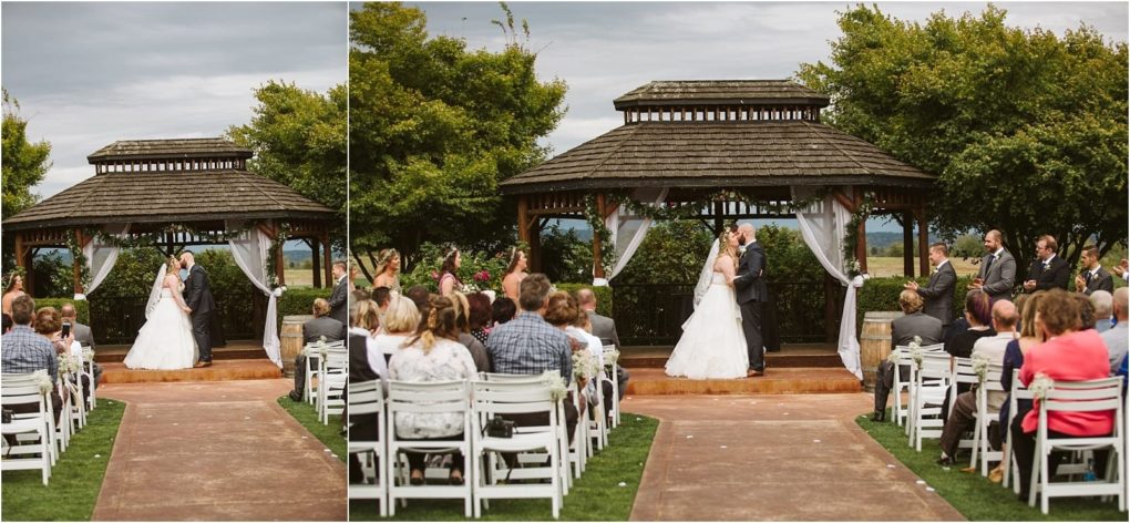 Premier snohomish & seattle wedding photographer | gsquared weddings photography a bride and groom share a kiss under a wooden gazebo during an outdoor snohomish wedding ceremony with guests on white chairs facing them on a green lawn Cloudy skies and lush trees frame this beautiful seattle area moment | serving snohomish seattle                   & beyond