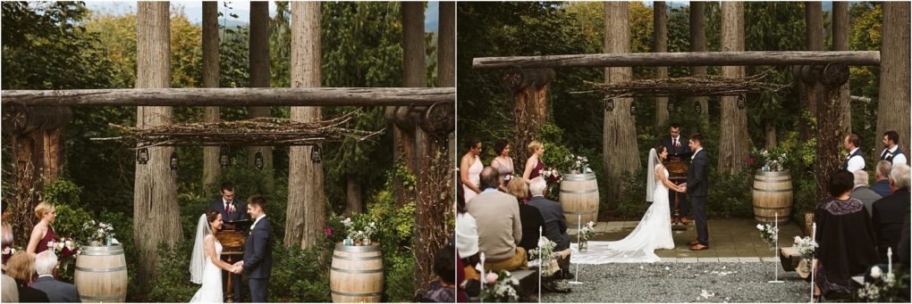 Premier snohomish & seattle wedding photographer | gsquared weddings photography a snohomish wedding ceremony outdoors a couple stands facing each other under a rustic wooden arbor surrounded by trees near seattle guests seated on both sides and two wine barrels framing the altar | serving snohomish seattle                   & beyond