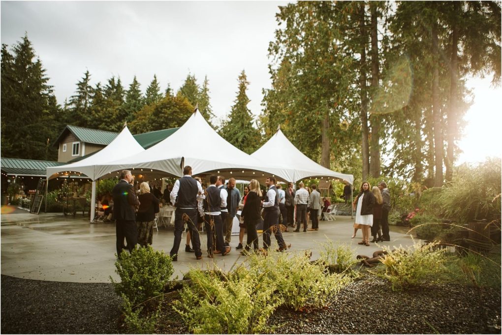 Premier snohomish & seattle wedding photographer | gsquared weddings photography a group gathers outdoors near white tents for a snohomish event surrounded by tall trees and greenery with the sun shiningperfect for a seattle wedding or engagement celebration | serving snohomish seattle                   & beyond