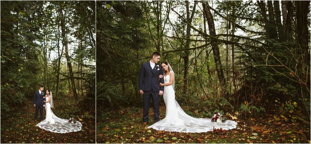Premier snohomish & seattle wedding photographer | gsquared weddings photography a bride and groom stand together in a forest clearing during their snohomish wedding The bride wears a long white dress with a lace train holding the grooms arm while fallen leaves and dense green trees surround them | serving snohomish seattle                   & beyond