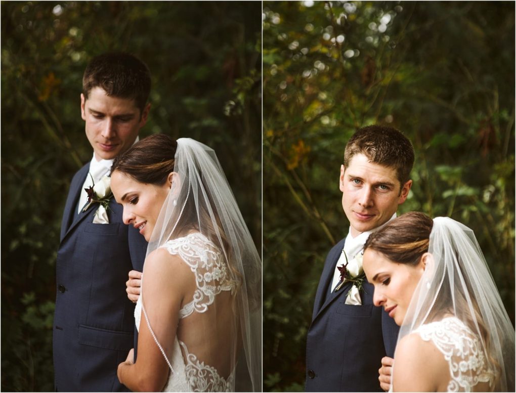 Premier snohomish & seattle wedding photographer | gsquared weddings photography a bride and groom stand closely together outdoors during their snohomish seattle wedding The bride in a lace dress and veil leans gently toward the groom in a navy suit with lush green foliage forming the natural background | serving snohomish seattle                   & beyond