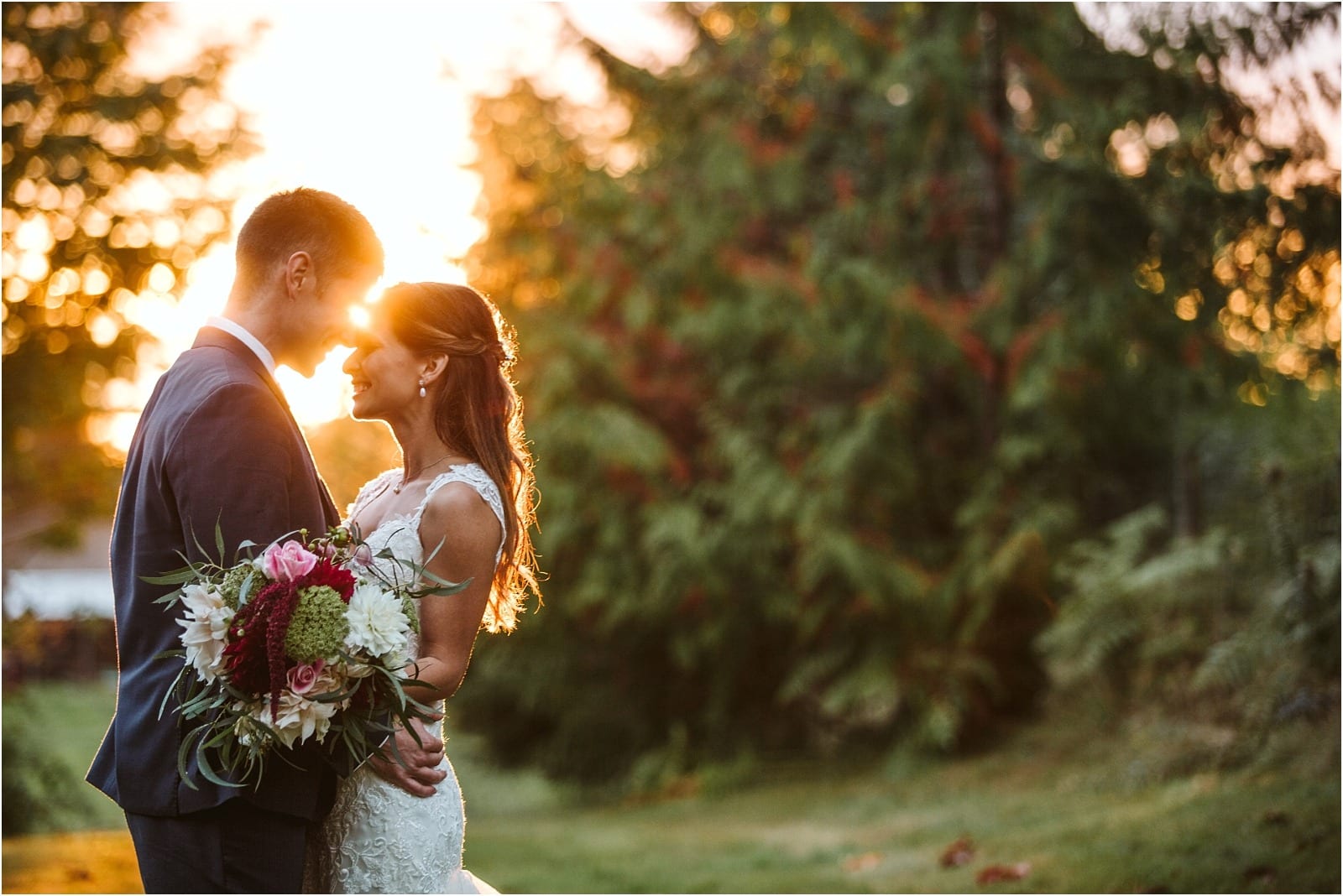 Premier Snohomish & Seattle Wedding Photographer | GSquared Weddings Photography A bride and groom stand close together outdoors at sunset, smiling and holding a bouquet of flowers, with soft sunlight filtering through trees in the background—a perfect Snohomish Seattle wedding moment.                                   | Serving Snohomish, Seattle ,                  & Beyond