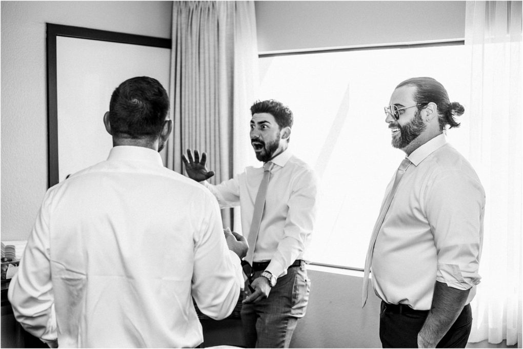 Premier snohomish & seattle wedding photographer | gsquared weddings photography three men in dress shirts and ties stand in a bright room smiling and talking One man gestures animatedly with his hands expressing excitementperhaps sharing a story from a recent snohomish seattle wedding engagement The atmosphere is lively and friendly | serving snohomish seattle                   & beyond