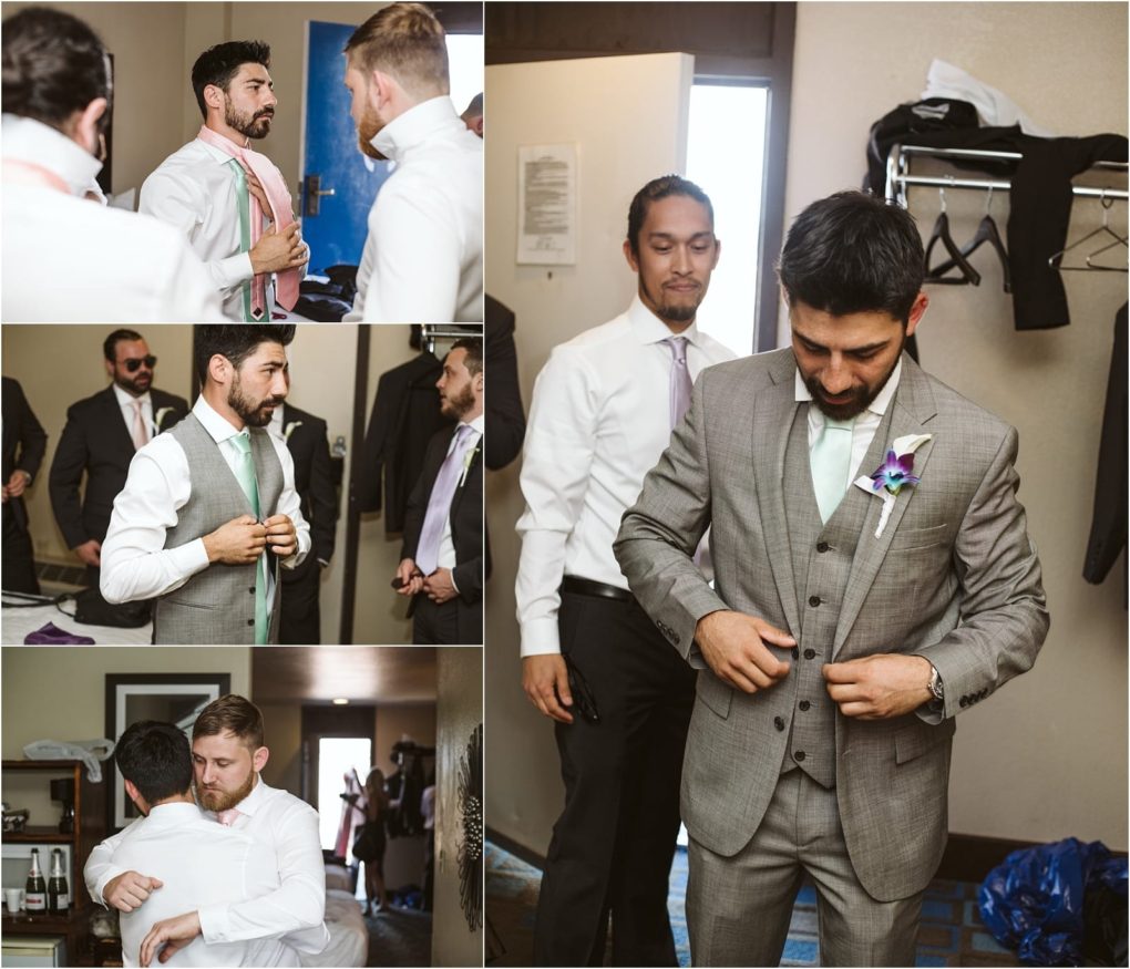 Premier snohomish & seattle wedding photographer | gsquared weddings photography a groom in a gray suit prepares with his groomsmen in a hotel room adjusting ties and jackets sharing moments and a hug before the snohomish seattle wedding ceremony | serving snohomish seattle                   & beyond